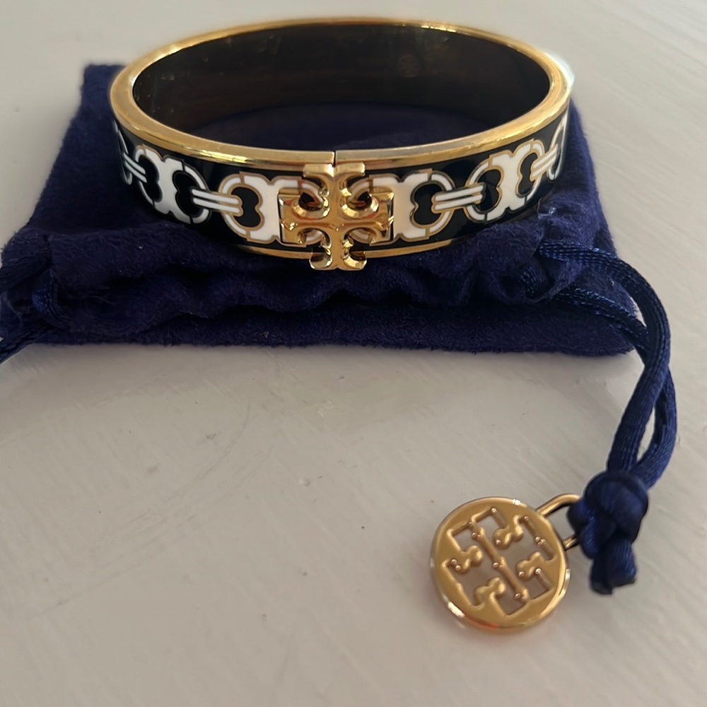 Tory Burch bangle style bracelet with hinge to open, pouch included.